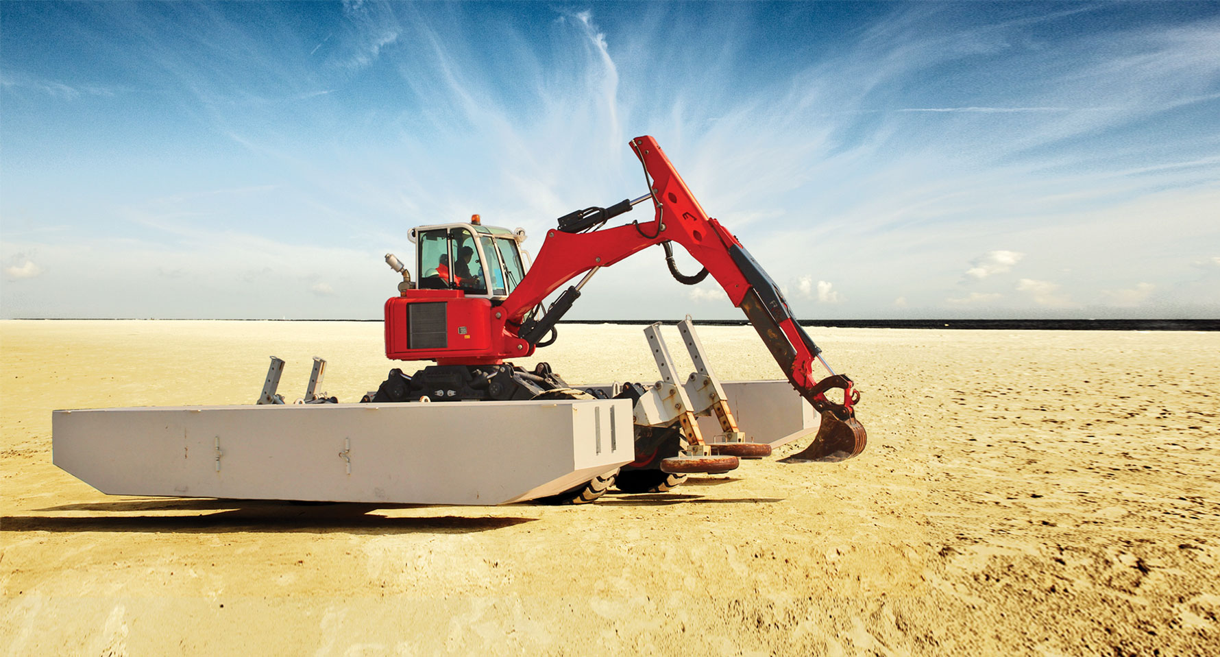 Thainex Aqua Spider Amphibious excavator drivin on land with wheels and attached pontoons.